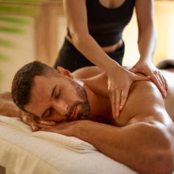 Young man having a massage by a professional masseuse